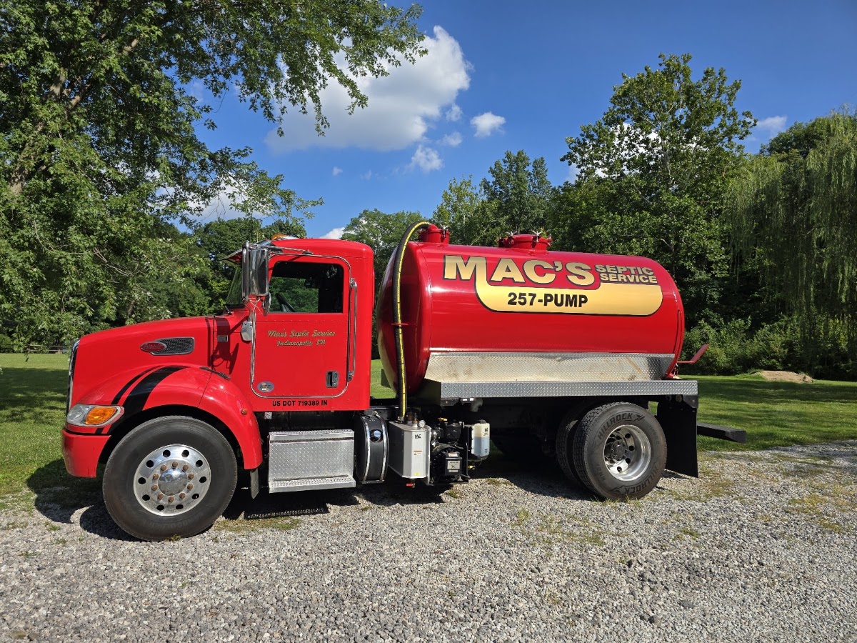 Mac's Septic Service all-red tanker truck parked on a gravel lot